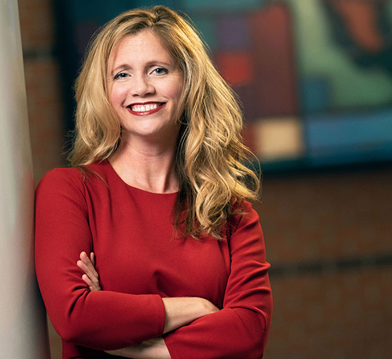 Woman in red Gonzaga t-shirt among fans cheering at basketball court